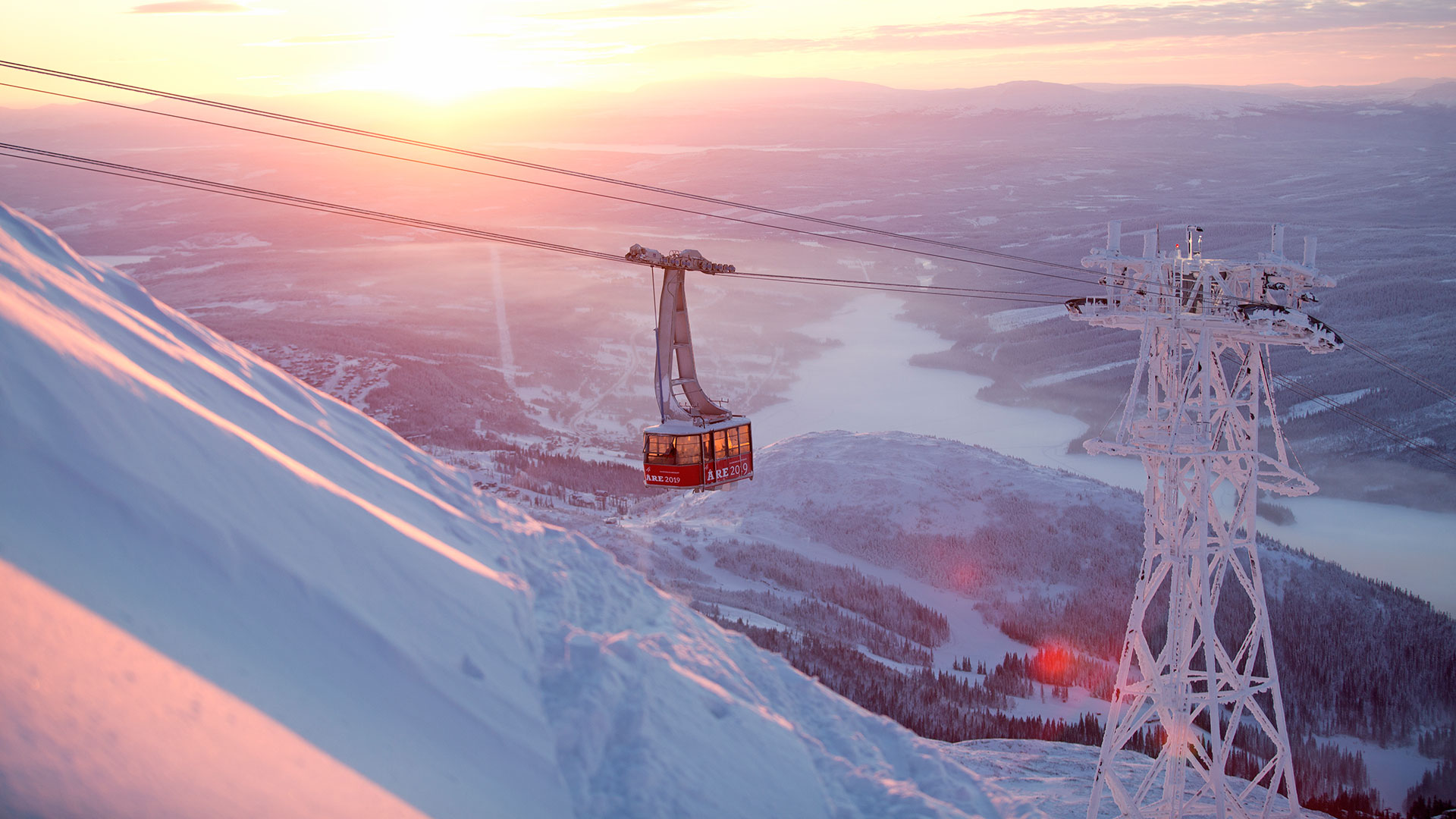 Landscape in Åre with cable car and snow-covered mountains at sunset