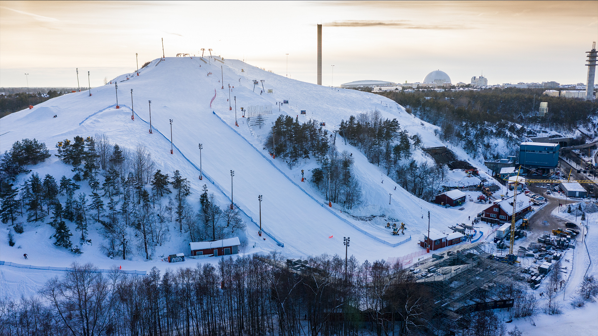 Snow-covered ski slope in Stockholm with Tele2 Arena and Globen in the background, winter landscape